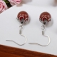 Boucles oreilles avec une pierre d'Agate Rouge ornées d'une cage de finition